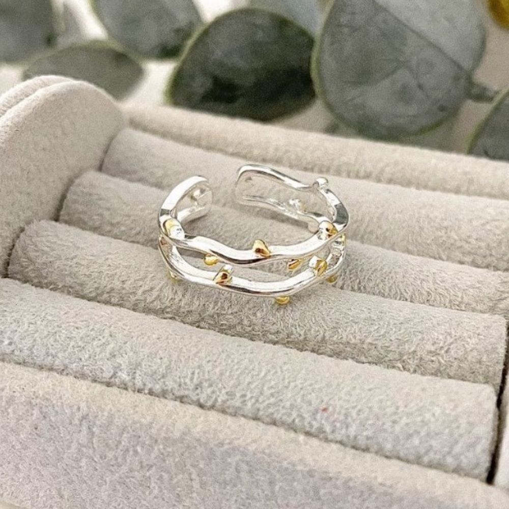 The Dainty Leaf adjustable silver ring with gold accents.